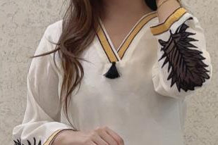 Trendy white kurti pant set with contrast embroidered bell sleeves &amp; tassel neckline.